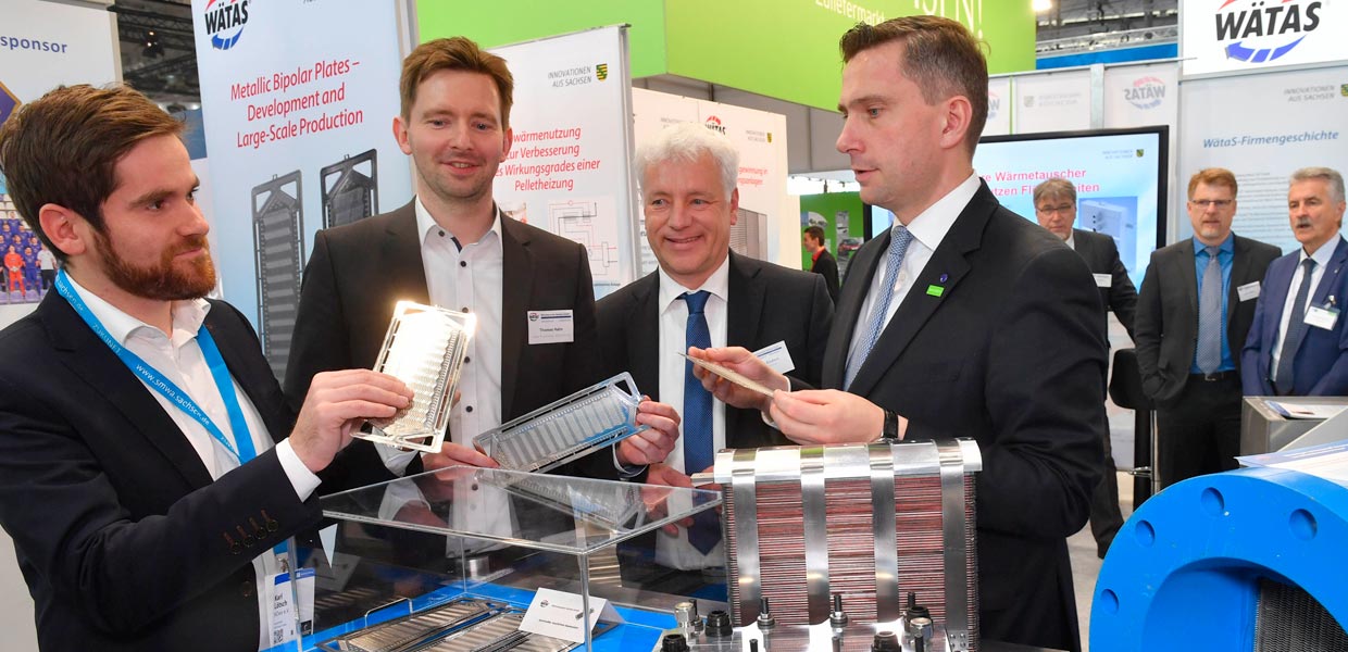 Bereits zur Hannover Messe 2019 stellten Karl Lötsch von HZwo sowie Thomas Hahn und Torsten Enders von Wätas dem sächsischen Wirtschaftsminister Martin Dulig Sachsens erste serientaugliche Bipolarplatte vor (v. l.). Diese Platten sind wesentliche Komponenten eines Brennstoffzellensystems. Die sächsischen Wertschöpfungspotenziale von Wasserstoff- und Brennstoffzellentechnologien werden in einer aktuellen Studie aufgezeigt.